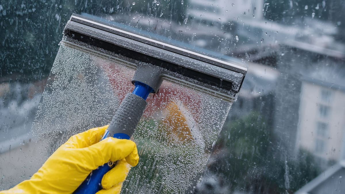 Deep-cleaning storefront window glass with professional equipment